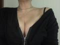 LadyMiller's chest showing cleavage in a black zip-up shirt with a black strap visible on her right shoulder. She's wearing a thin black necklace.