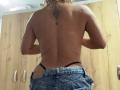 ElenaSaenz's topless back shows a sun tattoo between her shoulder blades. She's wearing low-rise jeans with a black thong, her wet, curly hair down.