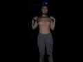 MollyMarmalade is topless with small tits, wearing gray dirty leggings, a blue helmet, and a black mouthpiece, standing against a dark background.