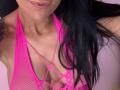 AndraD's pink mesh halter top reveals her small, perky tits with keyhole cutouts, showing her light brown skin and black hair falling over her shoulder.