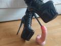 Black shiny platform heel with high stiletto stands next to a pink dildo with a circumcised head on wooden floor. MousseAuChocolat's boot is laced up tightly.