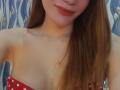 DianaShane has red polka dot strapless top, showing her bare tits, with long brown hair, red lipstick, and a slight smile, in a slightly blurred selfie.