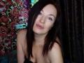 MarleneDavies has pale skin, blue eyes, and dark brown hair. She's topless with small tits, slightly parted pink lips, and a subtle, sexy smile.