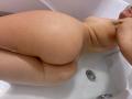 Naked MissJoliSourireBg in a white bathtub, showing her wet, round ass and back, with droplets of water on her light skin. Her face is partially visible.