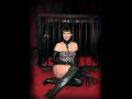 MaitresseElsa with black leather boots, gloves, and corset, sitting in a cage, wearing a chain collar, and showing her bare ass and boobs, with a red carpet.