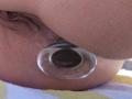 LaFrancaise's asshole with a clear glass butt plug, partially inserted, showing the plug's rounded, circular base against her brown, slightly hairy, and textured skin.